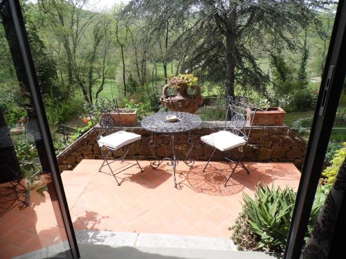 a patio with a table and chairs on a patio at La Loggetta - Apartments in Gaiole in Chianti
