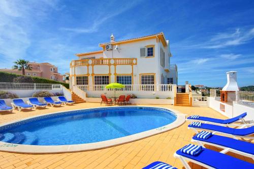 a villa with a swimming pool in front of a house at Villa Sunny in Albufeira