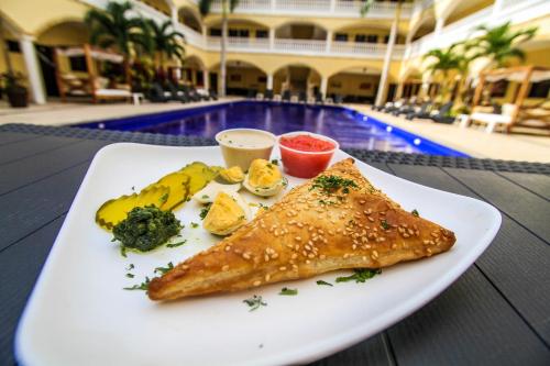 um prato de comida numa mesa ao lado de uma piscina em We playa Hotel-Hostel em Playa del Carmen