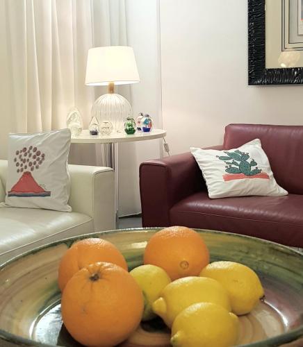 a bowl of oranges and lemons in a living room at La Foresteria Garden Boutique B&B in Catania