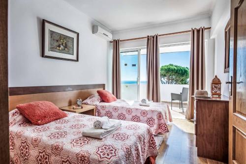 a hotel room with two beds and a window at Villa Oceano in Albufeira