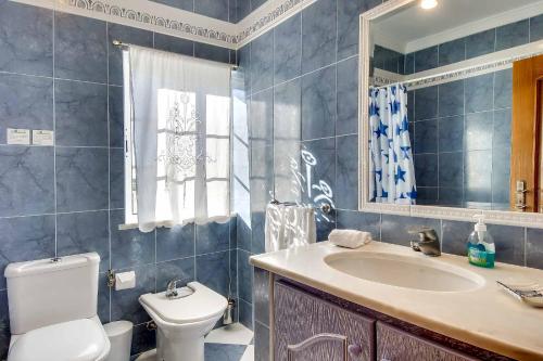 ein Badezimmer mit Waschbecken, Toilette und Spiegel in der Unterkunft Villa Sunny in Albufeira
