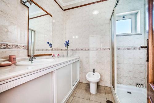 a bathroom with a sink and a toilet and a shower at Villa Oceano in Albufeira