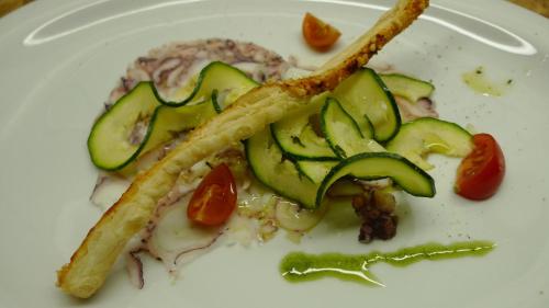 a white plate of food with cucumbers and tomatoes at Hotel Gardenazza in Badia