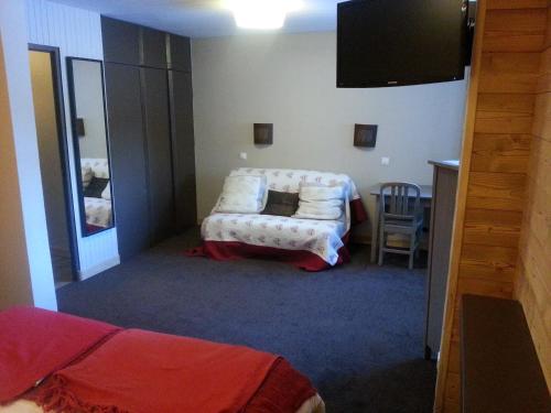 a room with a bed and a tv and a chair at Hôtel La Vanoise in Tignes