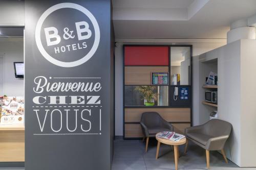 a waiting room with two chairs and a sign for a hotel at B&B HOTEL Avignon 2 in Le Pontet