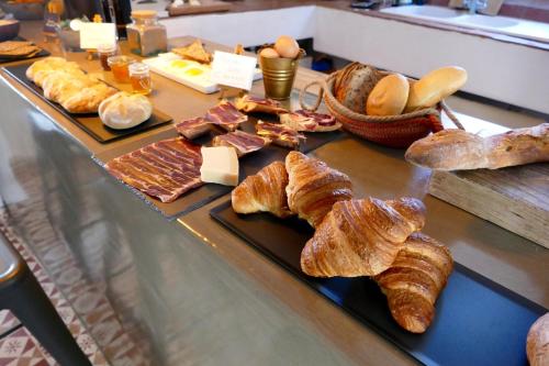 una mesa cubierta con diferentes tipos de pan y repostería en Casa Migdia, en Sant Jordi Desvalls