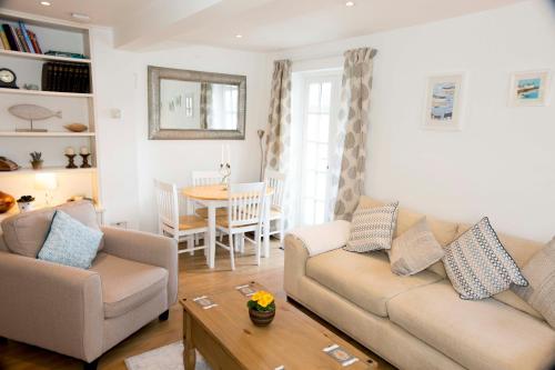 ein Wohnzimmer mit Sofa und Tisch in der Unterkunft Pixie Cottage in Eastbourne