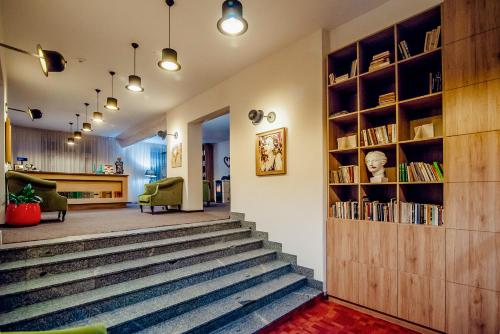 a living room filled with furniture next to a stair case at Bohema, Tubinas Hotels in Klaipėda
