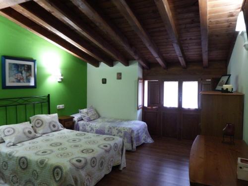 1 dormitorio con 2 camas y paredes verdes en La Casuca del Esbardu Hotel, en Vilde