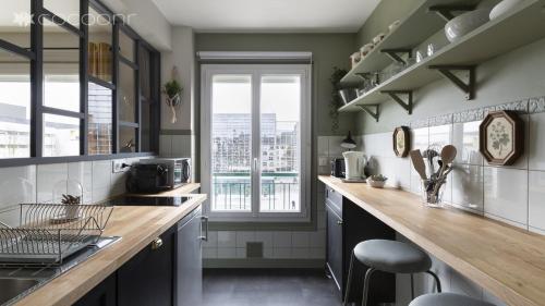 une cuisine avec un comptoir et une grande fenêtre dans l'établissement Le Phenix by Cocoonr, à Nantes