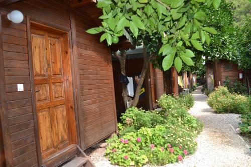 a building with a wooden door and some flowers at Olympos Doga Pansiyon in Olympos