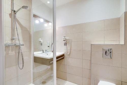 a bathroom with a shower and a sink at Logis Hôtel Marguerite in Orléans