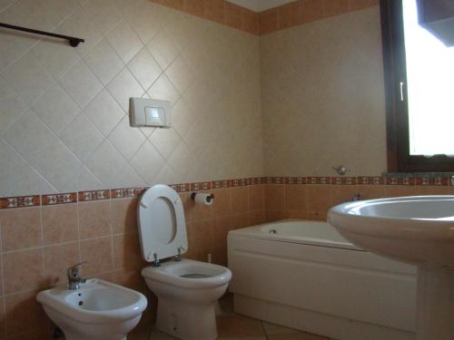 łazienka z toaletą i umywalką w obiekcie Appartamento Deledda w mieście Muravera