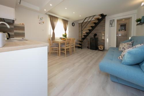 a kitchen and a living room with a blue couch at Apartman Urban Nature in Otočac