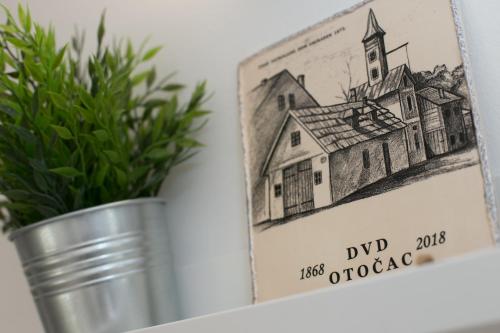 a drawing in a tin next to a plant at Apartman Urban Nature in Otočac