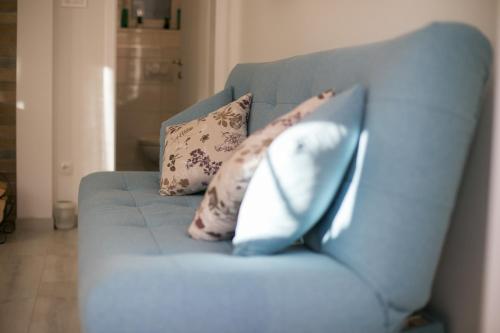 a blue couch with two pillows on it at Apartman Urban Nature in Otočac