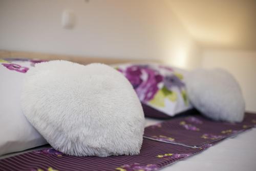 two white stuffed animals sitting on top of a bed at Apartman Urban Nature in Otočac