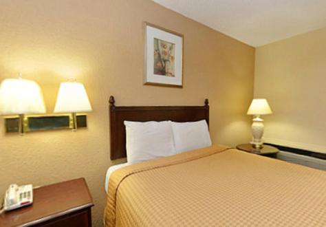 a hotel room with a bed and two lamps at Americas Best Value Inn Smithfield in Smithfield