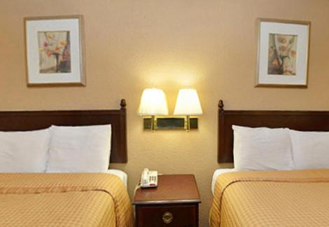 a hotel room with two beds and a phone on a table at Americas Best Value Inn Smithfield in Smithfield