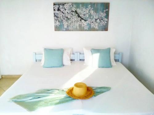 a straw hat sitting on top of a bed at Enalion House in Agios Ioannis Kaspaka