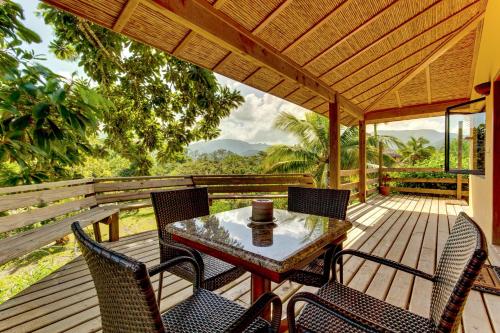 a patio with a table and chairs on a wooden deck at Sleeping Giant Rainforest Lodge in Belmopan