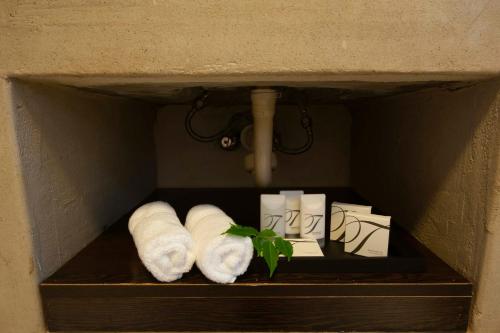 a shelf with towels and toilet paper and a plant at IL Castello in Clarens