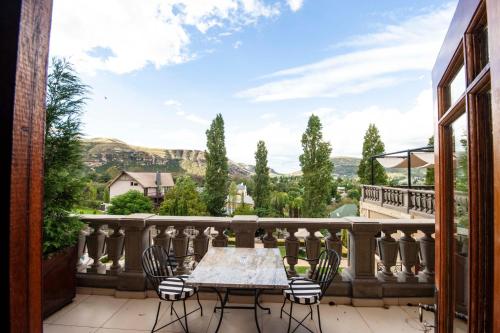 a patio with a table and chairs on a balcony at IL Castello in Clarens