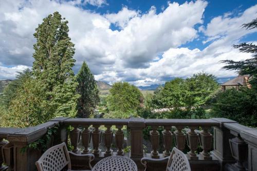 a balcony with chairs and a view of trees at IL Castello in Clarens