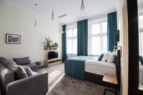 1 dormitorio con 1 cama y 1 sofá en Very Berry - Podgorna 1c - Old City Apartments, check in 24h, en Poznan
