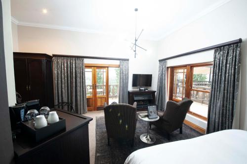 a hotel room with a bed and a desk and chairs at IL Castello in Clarens