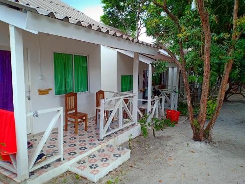 a house with chairs and a table and a tree at Sweet Time Bungalows in Koh Rong Sanloem
