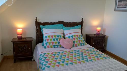 a bedroom with a bed with two night stands with two lamps at Gîte Cocantin in Trégomeur