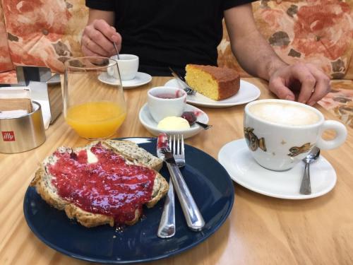 a person sitting at a table with a plate of breakfast food at A Casa dos Nores Charming House in Cangas de Morrazo
