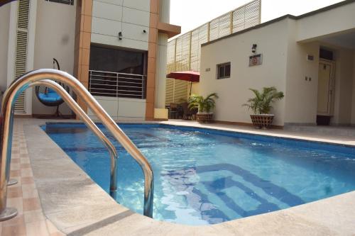 a swimming pool with a stairway leading to a building at Qualibest Grand Hotels in Abuja