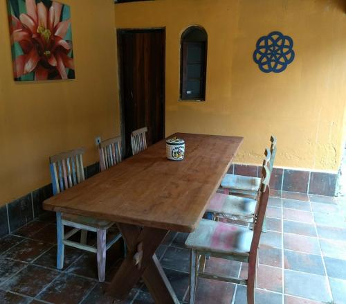 a wooden table and chairs in a room at Solar das Canoas Prumirim in Ubatuba