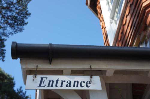 a sign for an entrance to a building at The Lawn Guest House Gatwick in Horley