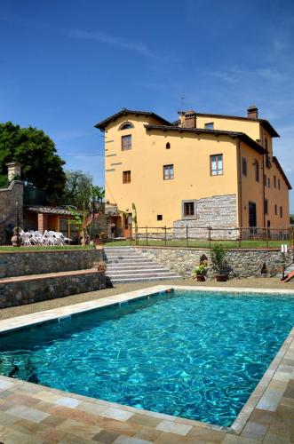 a house with a pool in front of a building at Agriturismo Il Poderaccio in Scandicci