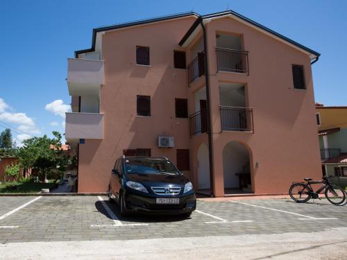a car parked in a parking lot in front of a building at Apartments Nives NB in Savudrija