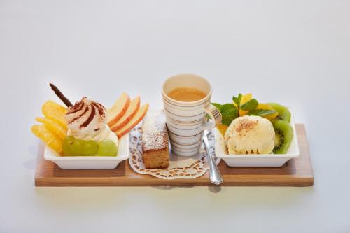 a tray with two plates of food and a cup of coffee at Hotel & Spezialitätenrestaurant zur Linde in Teufen