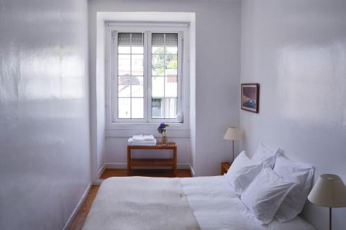 リスボンにあるFamily Apartment by the Riverの白いベッドルーム(ベッド1台、窓付)
