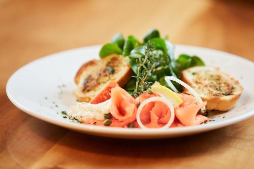 a plate of food with bread and vegetables on a table at Hotel & Spezialitätenrestaurant zur Linde in Teufen
