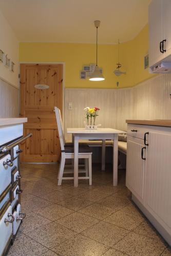 eine Küche mit einem Tisch und einer Blumenvase darauf in der Unterkunft InselGlück in Fehmarn