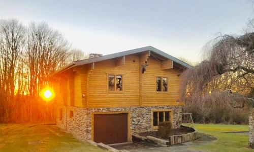 a wooden house with a garage in a yard at Chalet de Charme in Rochehaut
