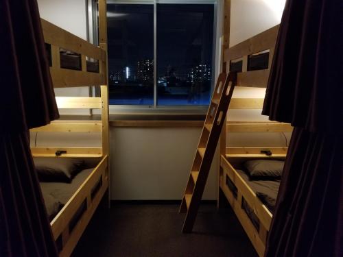 Divstāvu gulta vai divstāvu gultas numurā naktsmītnē Guesthouse Sumiyoshi