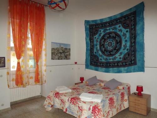 a bedroom with a bed and a tapestry on the wall at Casa Vacanze La Terra dei Briganti in Matera