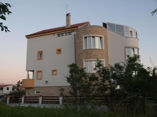 a large white building with a brick at Apartments and bungalows vila Dalibor in Nin