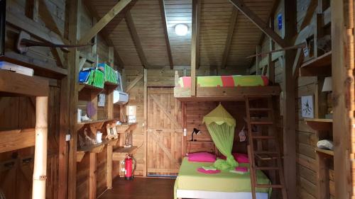 a room with bunk beds in a wooden cabin at les hauts de deshaies in Deshaies