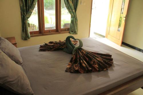 a large bed with a swan decoration on it at Watukarung Prapto Homestay in Kalak