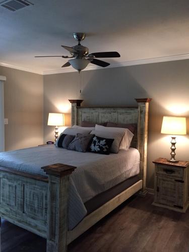 a bedroom with a bed with a ceiling fan and two lamps at Whitewater Condos in Canyon Lake
